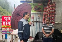 रिमझिम बारिश के बीच छाता लेकर आम लोगों से मिलने पहुंचे सीएम धामी
